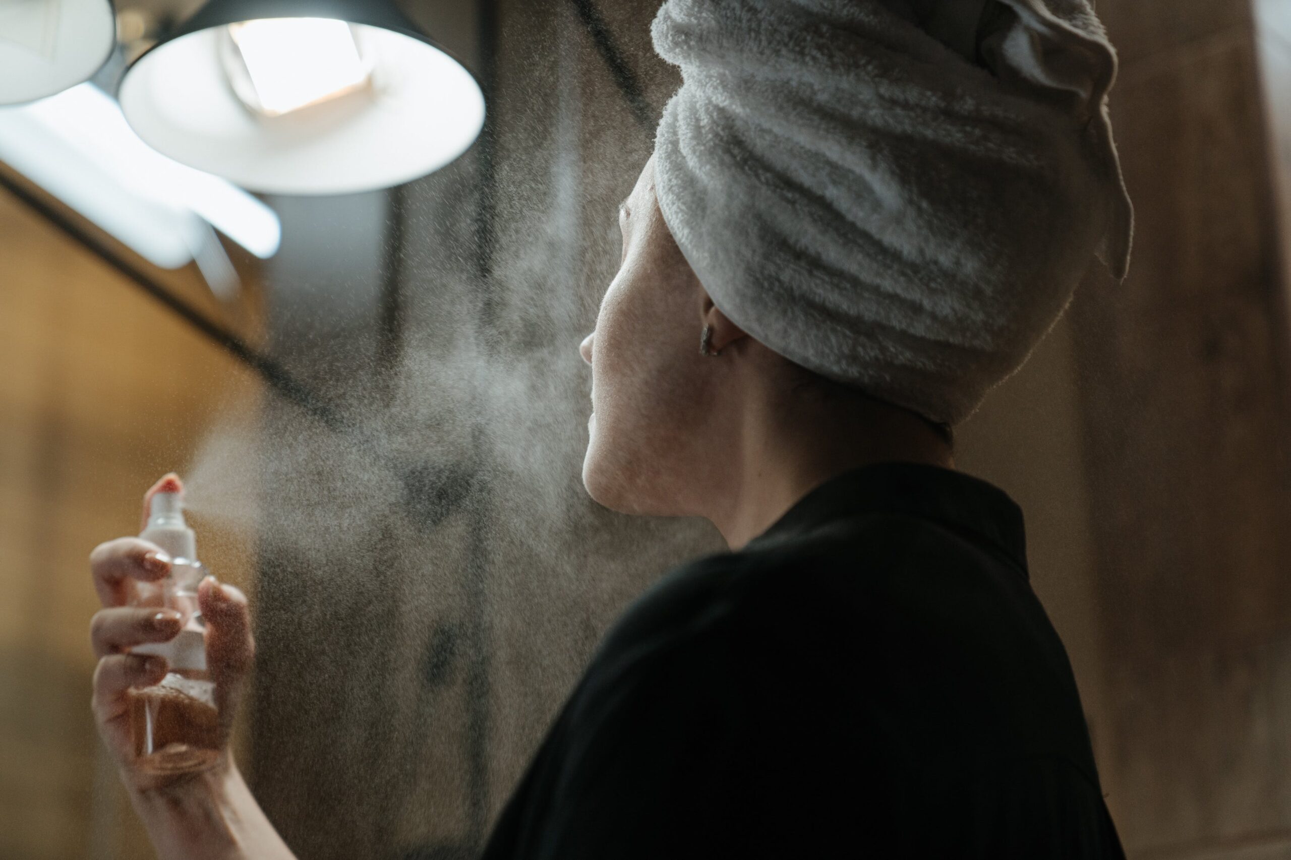 Woman trying different skincare ingredients to discover which suits her skin. Spray bottle is being used to spritz the face.