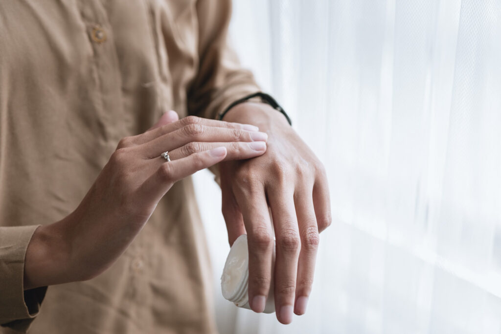 A person applying hand cream as a skincare routine