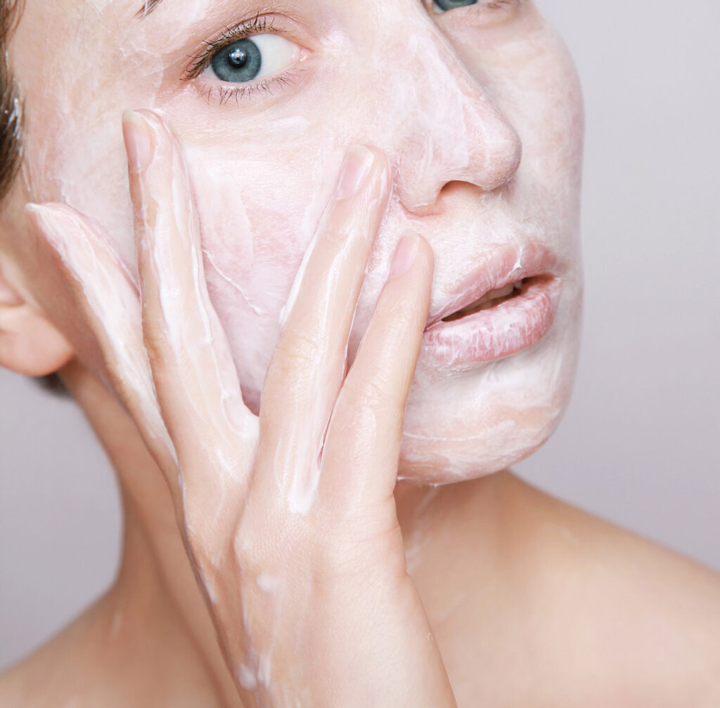 A person applying skincare products to face which will maintain skin health